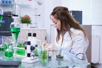 Female doctor examining chemical in laboratory