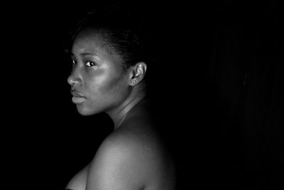 Thoughtful woman against black background