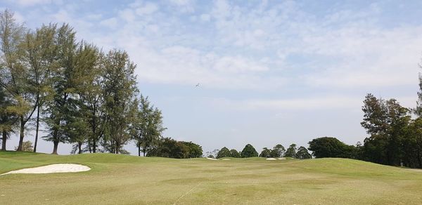 Scenic view of golf course against sky