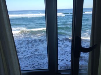 Close-up of sea seen through window