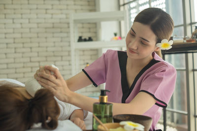 Young woman looking away while sitting at home