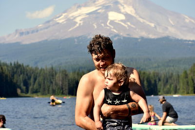 Father and son on mountain against mountains