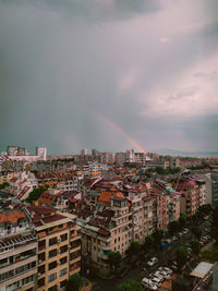 High angle view of rainbow over buildings in city