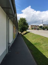 Road amidst buildings in city against sky