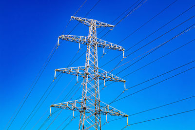 High-voltage power line and blue color metal prop with many electrical wires close up