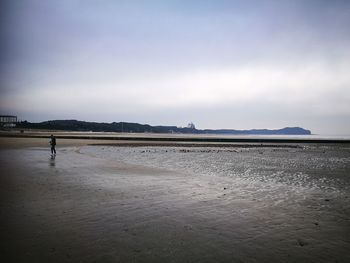 Man standing on beach against sky