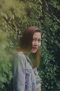 Portrait of a smiling girl standing against plants