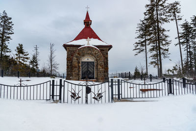 Built structure on snow covered field against sky