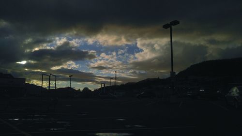 Road leading towards mountains against cloudy sky