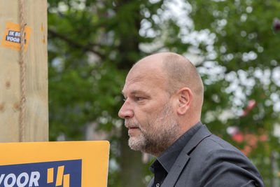 Portrait of man with text against trees