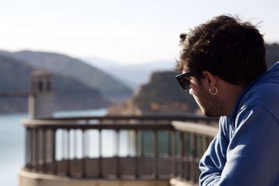 Portrait of young man wearing sunglasses against mountain