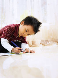 Close-up of cute boy drawing at home