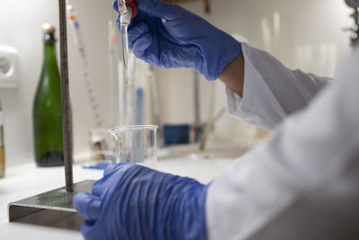 Close up of lab technician by placing a sample on beaker.