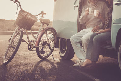 Low section of couple having drinks while sitting in motor home