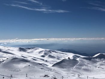 Scenic view of snowcapped mountains against blue sky