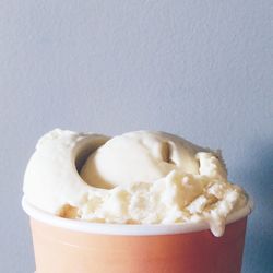 Close-up of ice cream cup against wall