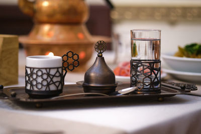 Water, espresso and a sugar container on a turkish-style tray.