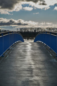 Bridge over calm sea against sky