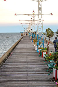 Pier over sea against sky during sunset