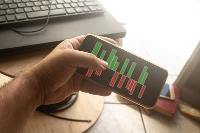 Midsection of person using mobile phone on table