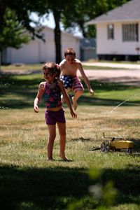 Full length of mother and girl standing on grass