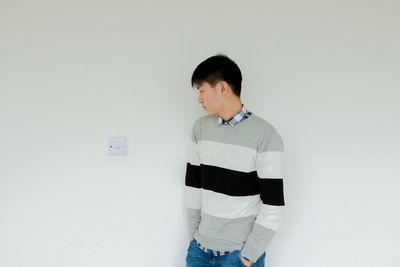 Young woman standing against white background