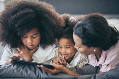 Women looking at camera while using smart phone