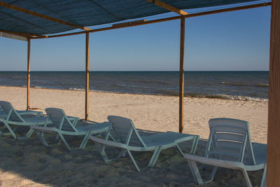 Empty chairs and tables at beach. empty lounge beds on coast.