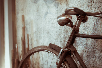 Close-up of bicycle parked by wall