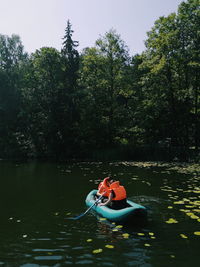 Boat floating on lake against trees