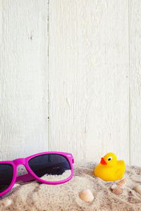 Close-up of sunglasses on toy against wall