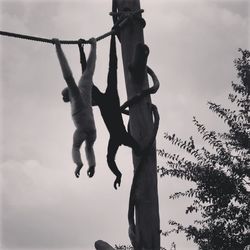 Low angle view of silhouette rope hanging against sky