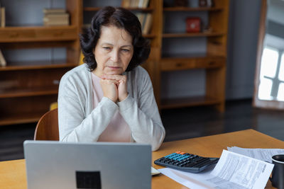 Young woman using laptop at table