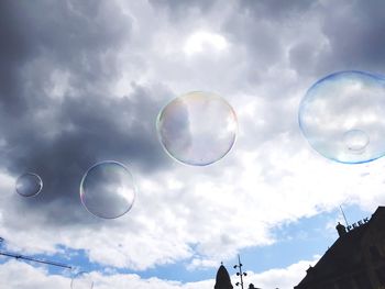 Low angle view of bubbles against rainbow in sky