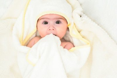 Portrait of cute baby girl wrapped in blanket