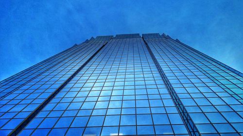 Low angle view of modern building against blue sky