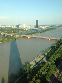 High angle view of city by river and buildings against sky