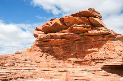Rock formation against cloudy sky