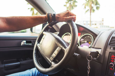 Midsection of man using mobile phone in car