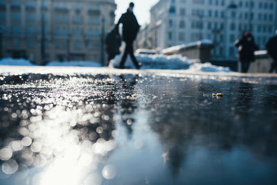 Man walking on wet street in city