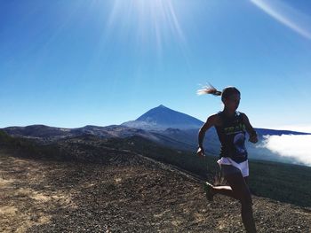 Full length of man on mountain against sky on sunny day