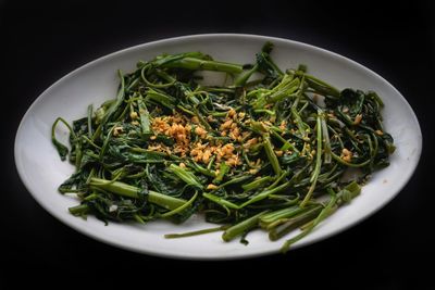 Directly above shot of chopped vegetables in plate against black background