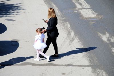 Side view of woman with child walking on street