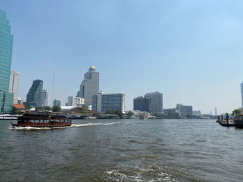 Scenic view of river and buildings against clear sky