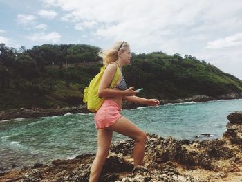 Side view of woman walking on rocky shore