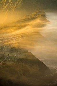 Aerial view of mountain by sea in foggy weather