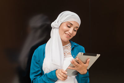 Smiling woman using digital tablet outdoors