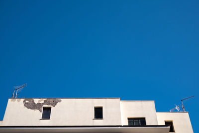 Low angle view of building against clear blue sky