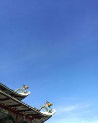 Low angle view of statue against blue sky