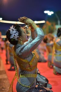 Side view of woman in costume dancing on stage